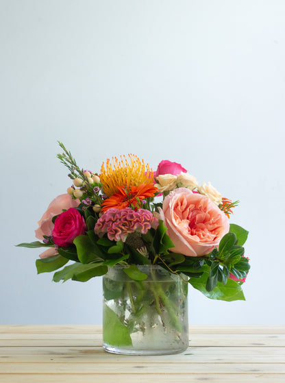Bright floral arrangement in a short vase. Photography by Vibeke Silverthorne, 2023